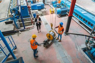 Aerial view of three employees discussing a product in a research facility.