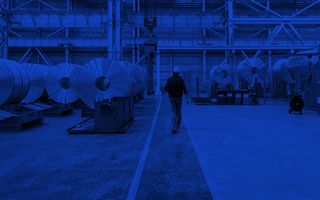 Engineering worker walking through a steel warehouse.