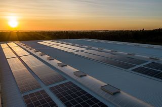 Sun setting behind a large expansive view of a solar panel field.