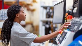 Technician working with engineering and computing equipment.