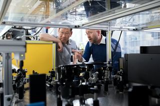 Two engineering employees discussing a piece of technical equipment in the testing work environment.
