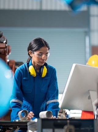 Engineer making design updates on a computer in a testing facility.